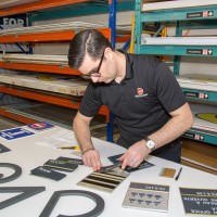 Miller McConnell staff member working on braille signage